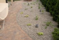 Minimalistyczna rabata ogrodowa wyłożona kamieniem